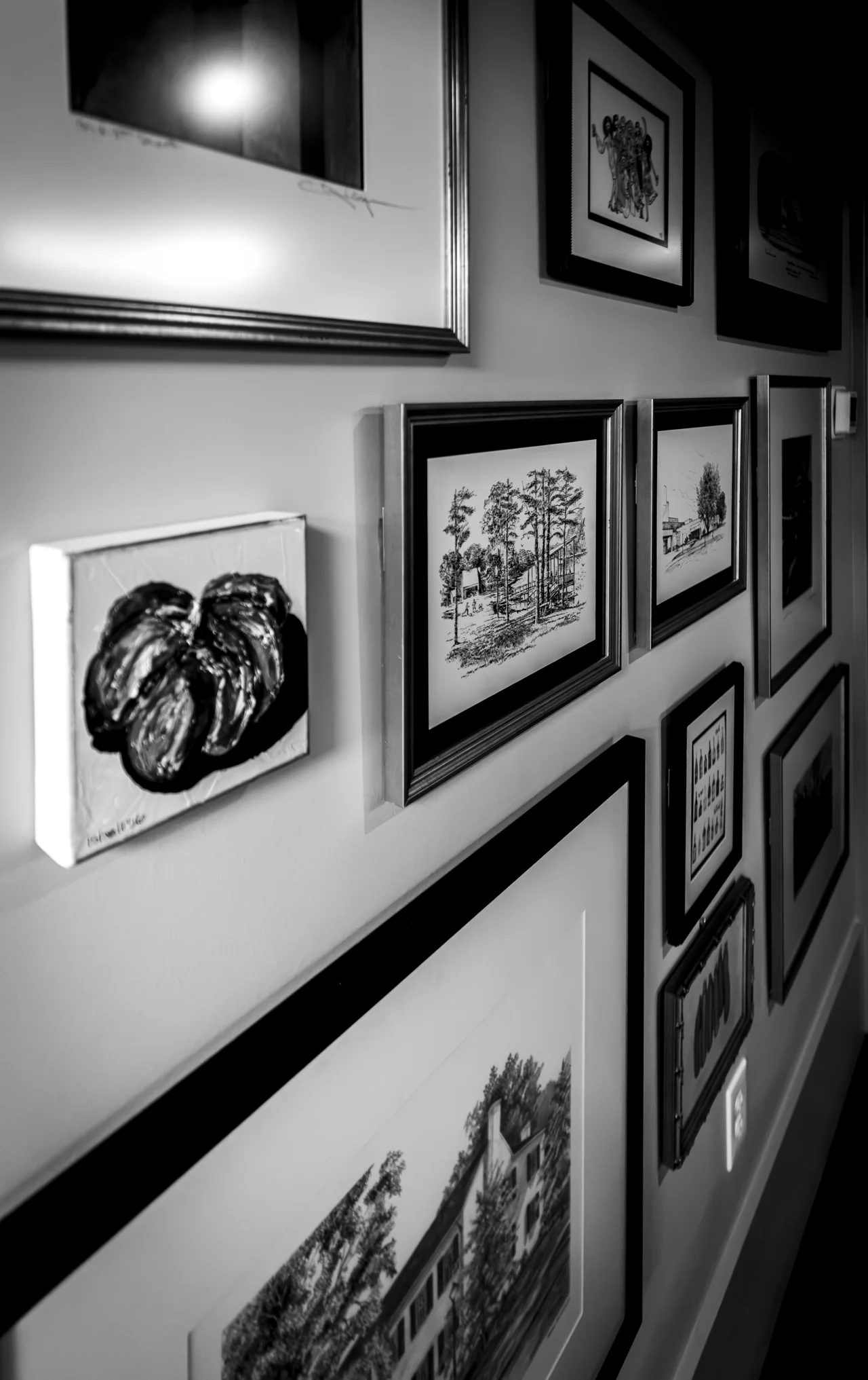 Framed photographs line a restaurant wall in an angled interior view.