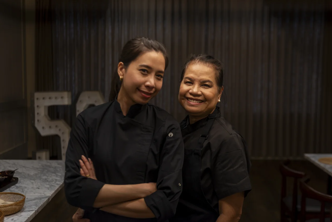 Two members of a restaurant team stand together for a portrait.