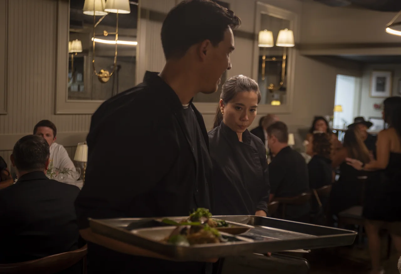A server attends to guests during a restaurant dinner.