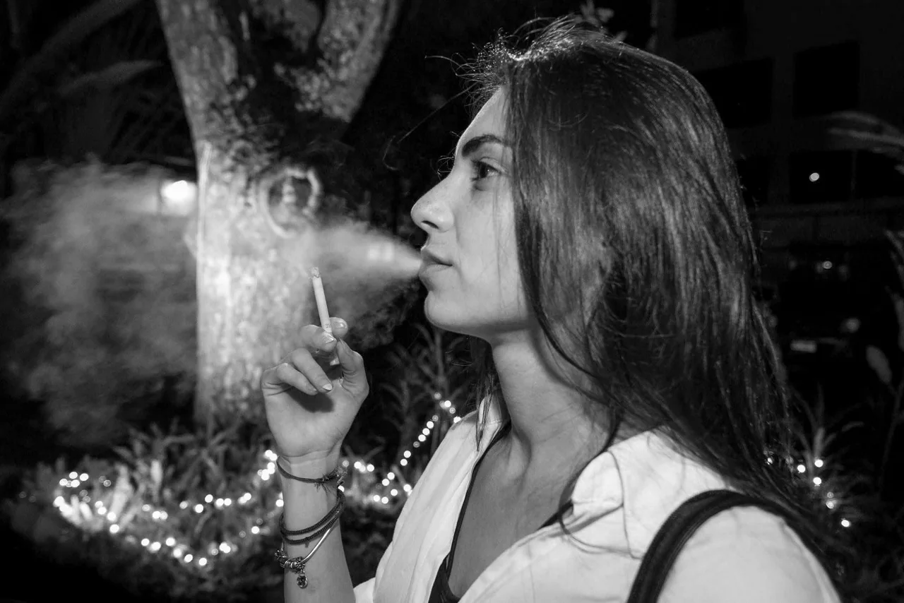 A monochrome profile portrait with long hair and drifting smoke.